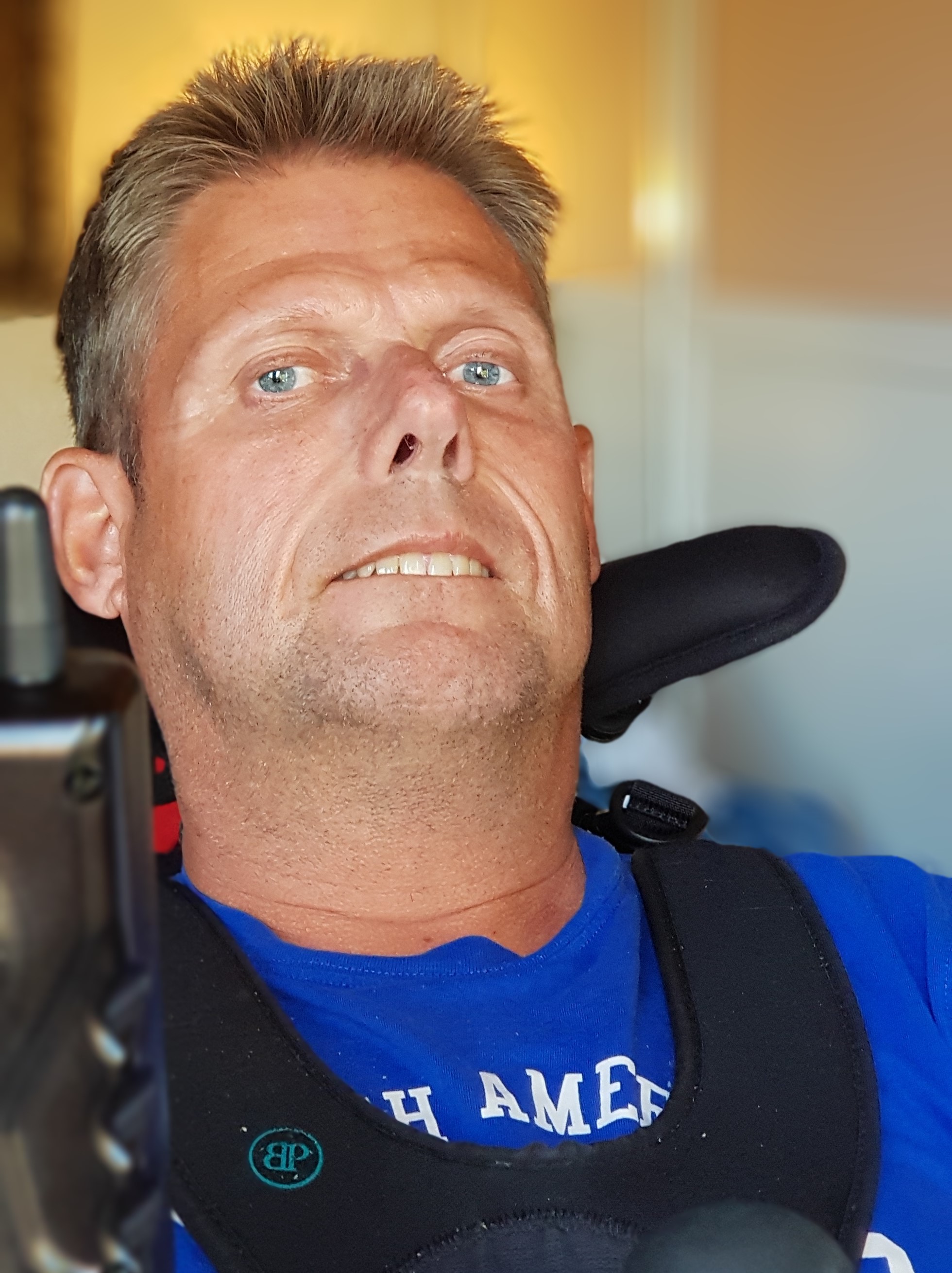 Mikael Granberg i sin rullstol med blå t-shirt och bålsele